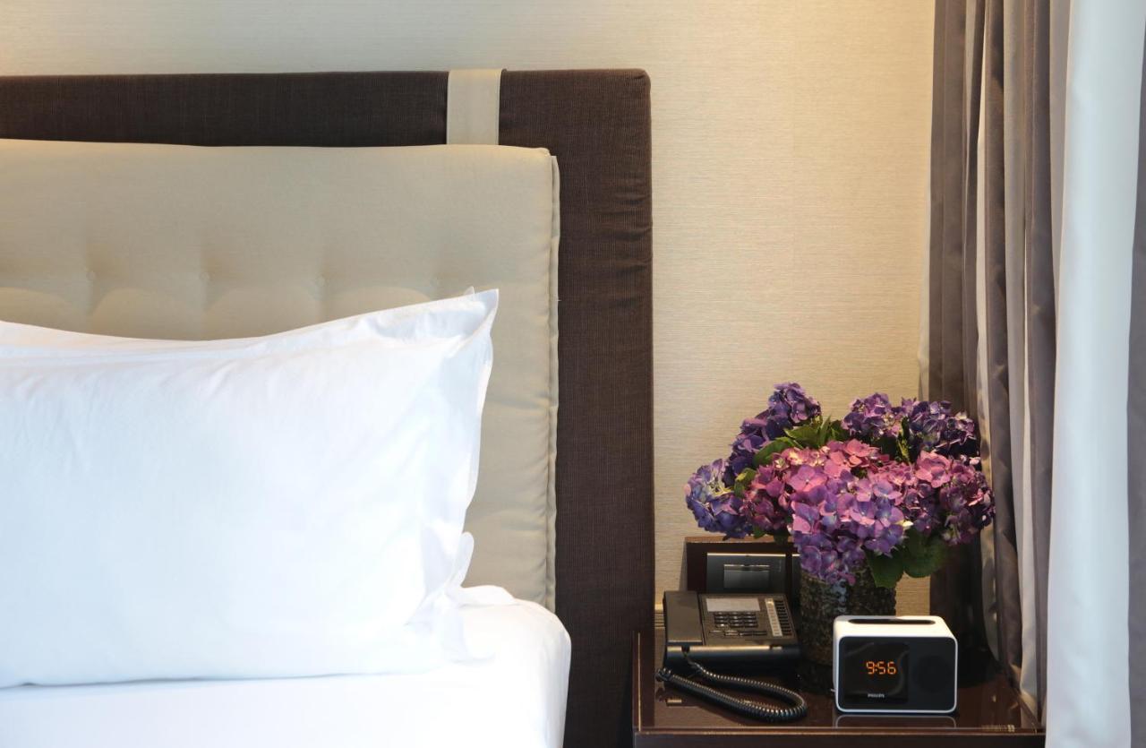 Makati Diamond Residences Makati City Exterior photo A bedside table with a telephone, a vase of flowers, and a digital alarm clock